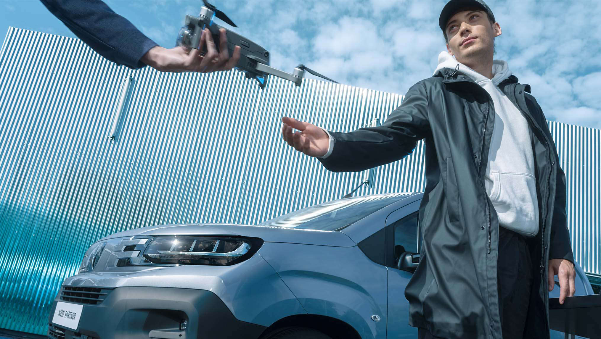 Peugeot Partner, вигляд спереду з лівого боку, два чоловіки з коптером